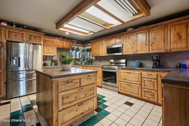 kitchen with a kitchen island, dark countertops, light tile patterned floors, and stainless steel appliances