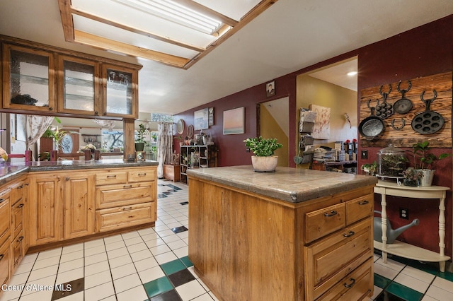 kitchen featuring tile countertops, light tile patterned floors, and glass insert cabinets