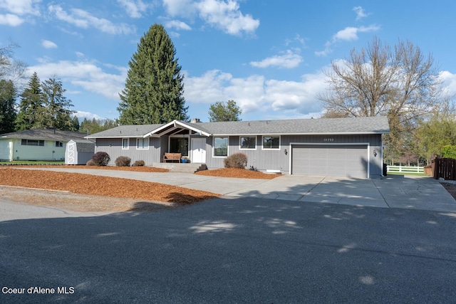 10792 N Magic Ct, Hayden, ID 83835 - single story home featuring a storage unit, an attached garage, driveway, fence, and an outbuilding