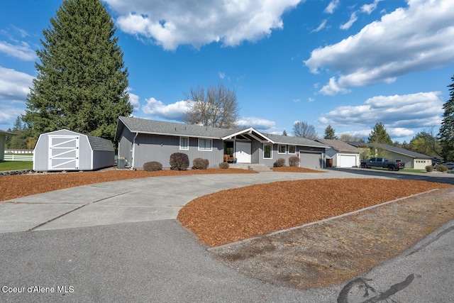 10792 N Magic Ct, Hayden, ID 83835 - ranch-style home with curved driveway, a shed, and an outbuilding