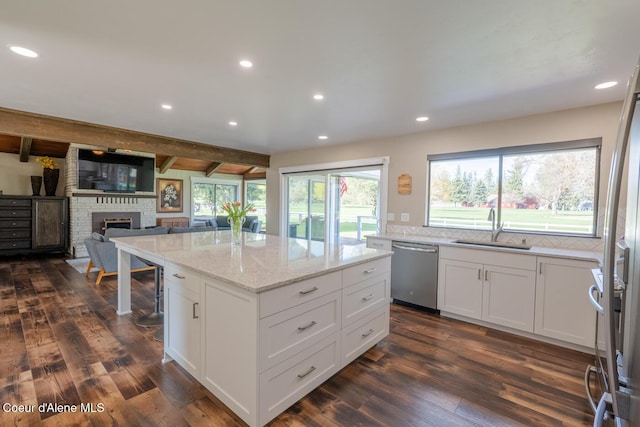 10792 N Magic Ct, Hayden, ID 83835 - kitchen with stainless steel dishwasher, a sink, dark wood-style flooring, a kitchen island, and light stone countertops