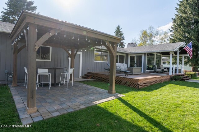 10792 N Magic Ct, Hayden, ID 83835 - rear view of house featuring a wooden deck, a lawn, a patio, board and batten siding, and a chimney