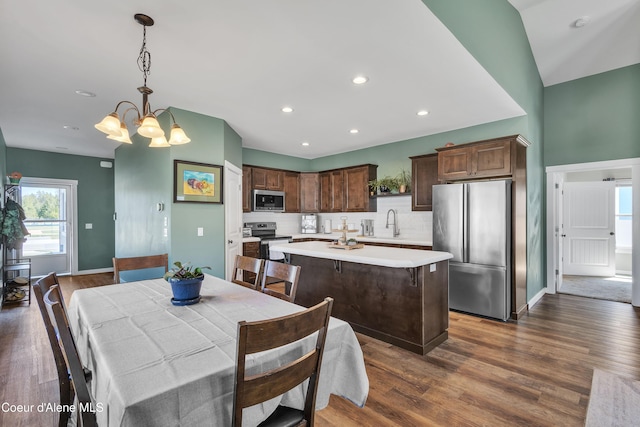 dining room featuring baseboards, dark wood-style flooring, an inviting chandelier, and recessed lighting