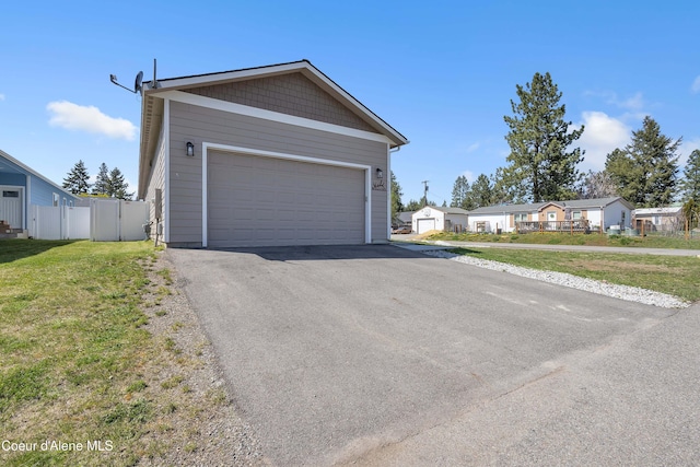 view of front of home featuring a garage, fence, and a front yard