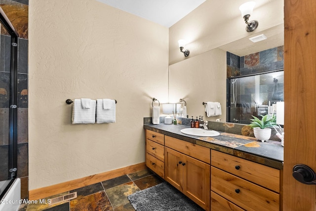 504 Hornby Pl, Dover, ID 83825 - bathroom featuring stone tile floors, a shower with shower door, baseboards, and vanity