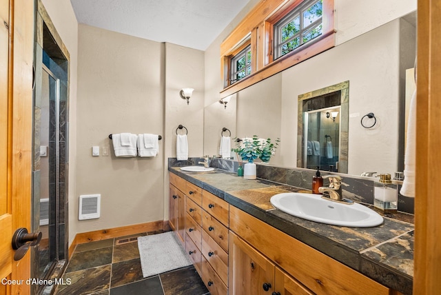 504 Hornby Pl, Dover, ID 83825 - full bathroom featuring stone finish flooring, a stall shower, double vanity, baseboards, and heating unit