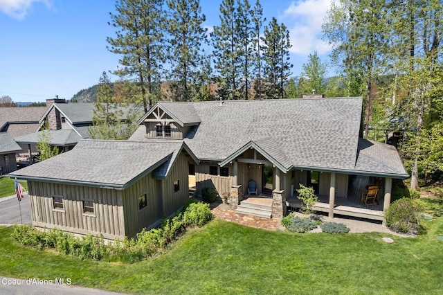 504 Hornby Pl, Dover, ID 83825 - view of front of property featuring a shingled roof, board and batten siding, a front lawn, and covered porch