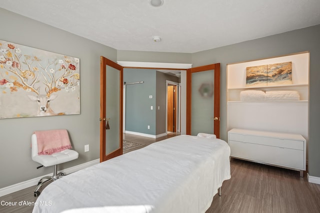 bedroom with wood finished floors and baseboards