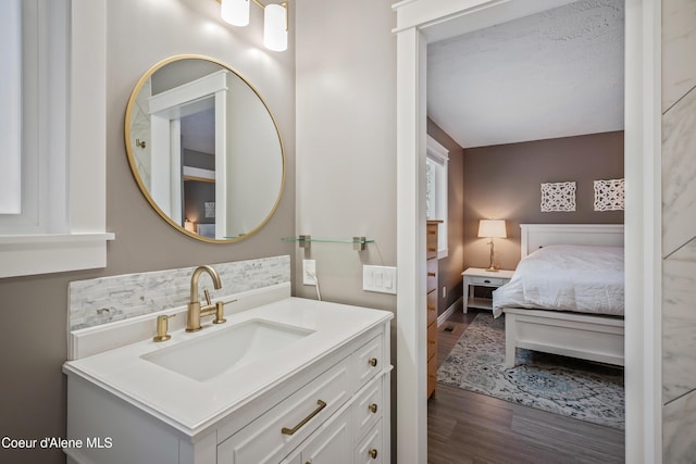 ensuite bathroom with vanity, ensuite bathroom, and wood finished floors