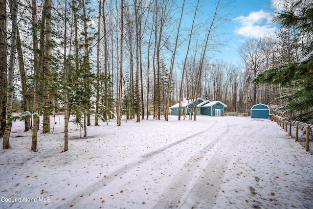 snowy yard with an outbuilding and a shed