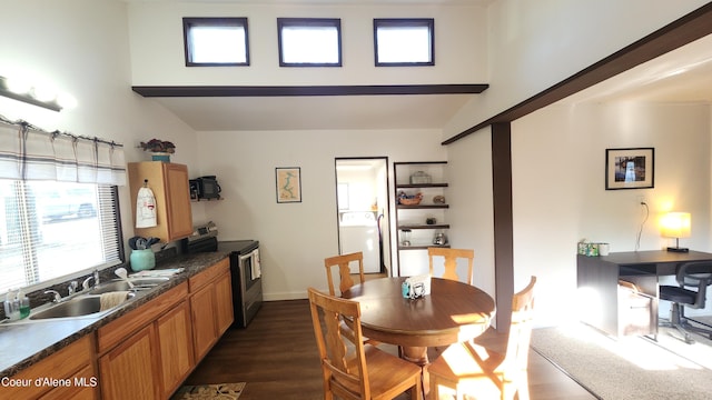 dining space with baseboards, a high ceiling, dark wood finished floors, and washer / clothes dryer
