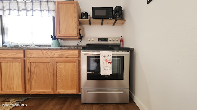 kitchen with stainless steel range with electric cooktop, dark countertops, black microwave, dark wood finished floors, and baseboards