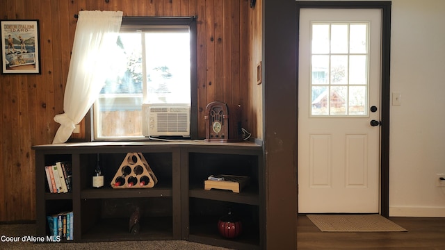 doorway to outside with wooden walls, baseboards, and wood finished floors