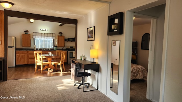 interior space with dark carpet and lofted ceiling with beams