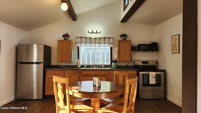 kitchen with dark wood-style flooring, dark countertops, appliances with stainless steel finishes, and lofted ceiling with beams