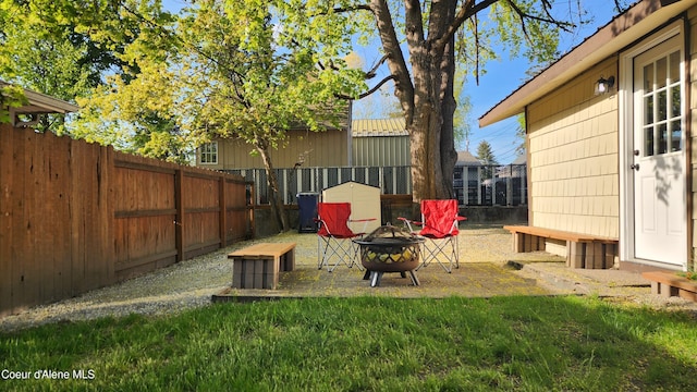 view of yard featuring a fenced backyard and a fire pit