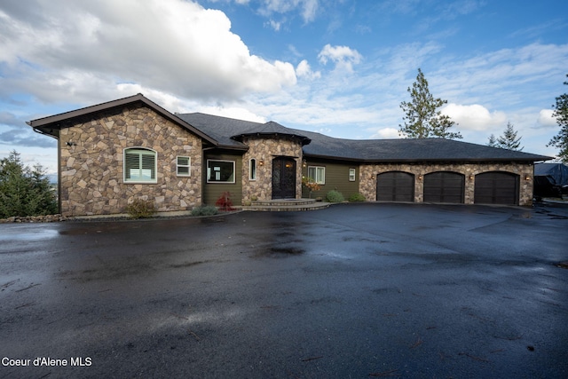 5969 W Highland Dr, Coeur Dalene, ID 83814 - view of front of property with an attached garage, driveway, and stone siding