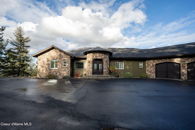 5969 W Highland Dr, Coeur Dalene, ID 83814 - view of front facade with a garage, driveway, and stone siding
