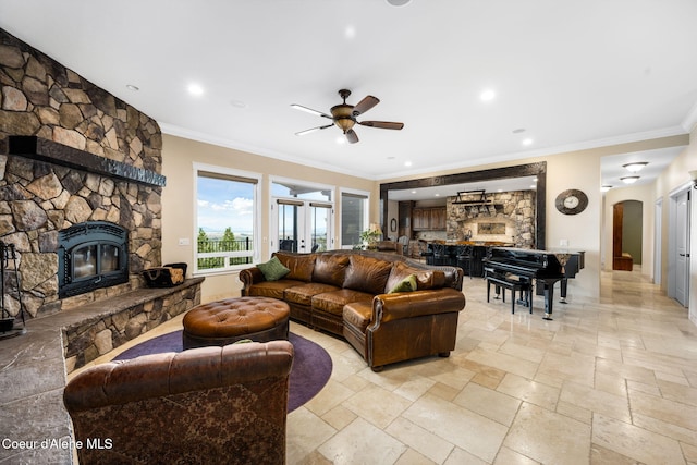 5969 W Highland Dr, Coeur Dalene, ID 83814 - living room featuring crown molding, stone tile flooring, a fireplace, ceiling fan, and arched walkways