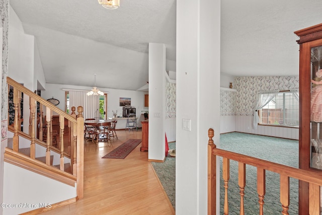404 W 18th Ave, Post Falls, ID 83854 - entrance foyer featuring an inviting chandelier, a textured ceiling, wood finished floors, and a healthy amount of sunlight
