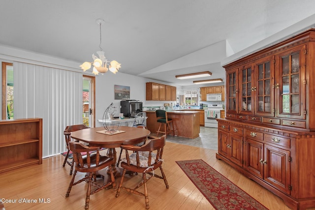 404 W 18th Ave, Post Falls, ID 83854 - dining space featuring light wood-style floors, vaulted ceiling, and a notable chandelier