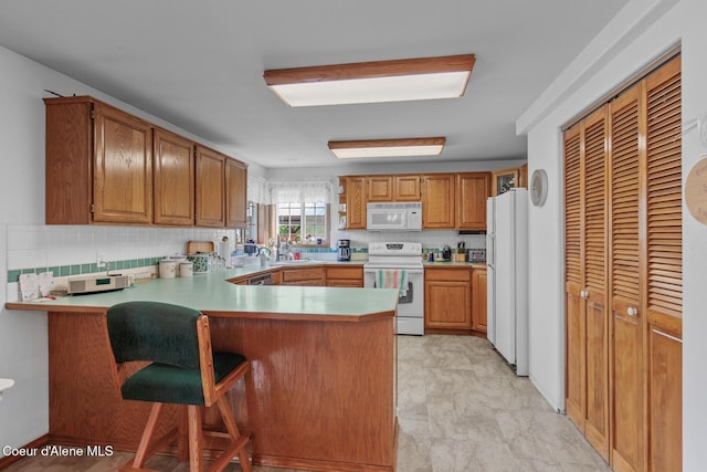 404 W 18th Ave, Post Falls, ID 83854 - kitchen featuring a peninsula, tasteful backsplash, a sink, and white appliances