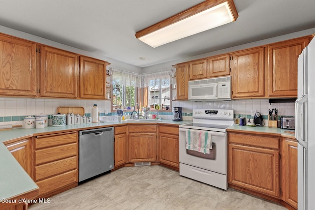 404 W 18th Ave, Post Falls, ID 83854 - kitchen with a sink, white appliances, brown cabinetry, backsplash, and light countertops