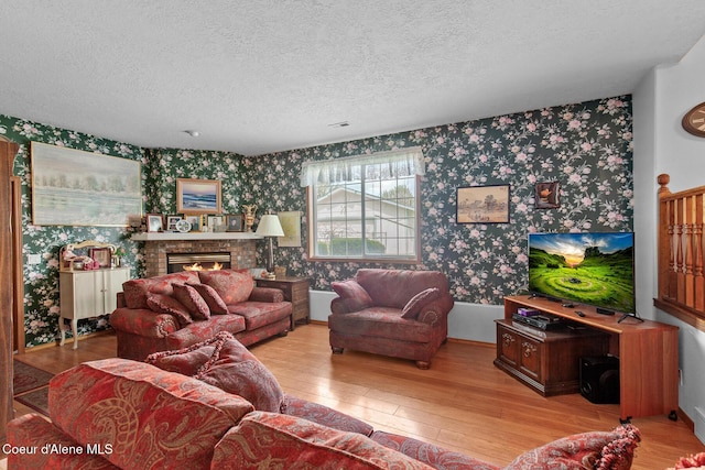 404 W 18th Ave, Post Falls, ID 83854 - living area featuring wallpapered walls, a textured ceiling, a brick fireplace, and wood-type flooring