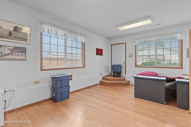 404 W 18th Ave, Post Falls, ID 83854 - home office with light wood-type flooring, a wood stove, a healthy amount of sunlight, and visible vents