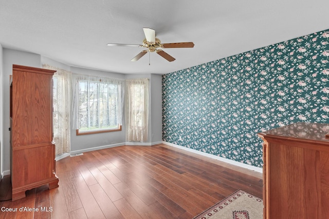 404 W 18th Ave, Post Falls, ID 83854 - empty room with a ceiling fan, wallpapered walls, baseboards, visible vents, and wood finished floors