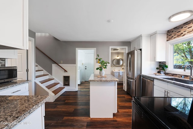 723 Forest Ave, Sandpoint, ID 83864 - kitchen with appliances with stainless steel finishes, a sink, light stone counters, a center island, and white cabinetry