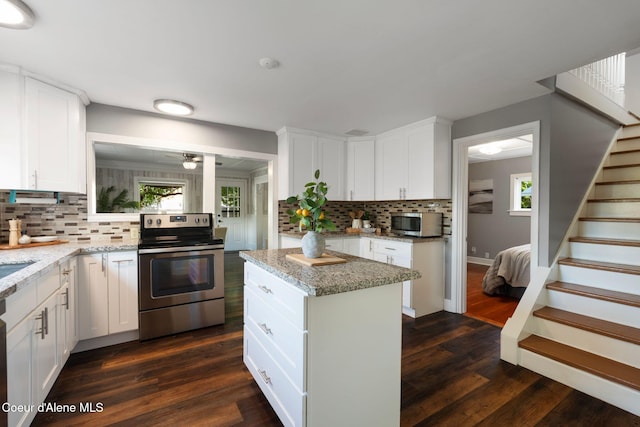 723 Forest Ave, Sandpoint, ID 83864 - kitchen with stainless steel appliances, backsplash, dark wood-type flooring, and white cabinetry