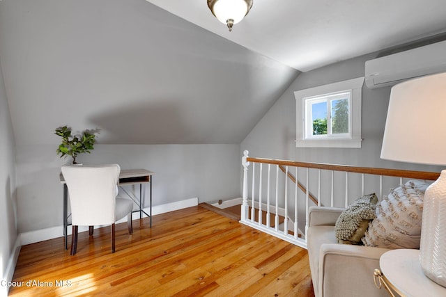 723 Forest Ave, Sandpoint, ID 83864 - sitting room featuring an upstairs landing, lofted ceiling, a wall mounted AC, hardwood / wood-style floors, and baseboards