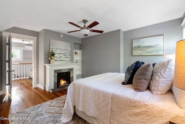 723 Forest Ave, Sandpoint, ID 83864 - bedroom with hardwood / wood-style flooring, a tiled fireplace, and ceiling fan