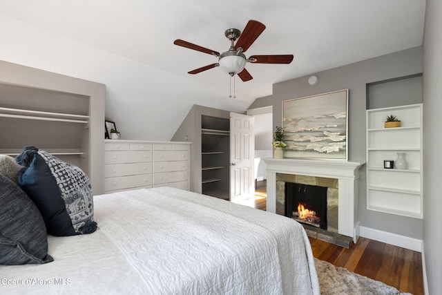 723 Forest Ave, Sandpoint, ID 83864 - bedroom featuring wood finished floors, a warm lit fireplace, vaulted ceiling, and a ceiling fan