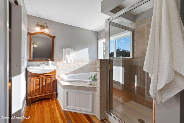 723 Forest Ave, Sandpoint, ID 83864 - bathroom with vanity, a garden tub, a shower stall, and wood finished floors