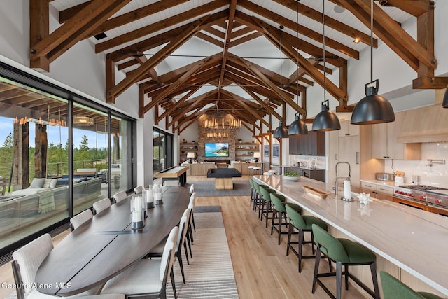 6869 S Gozzer Rd Unit C201, Harrison, ID 83833 - dining area with high vaulted ceiling, light wood-type flooring, a chandelier, and wooden ceiling with exposed beams