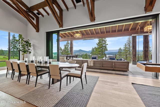 6869 S Gozzer Rd Unit C201, Harrison, ID 83833 - dining area featuring a mountain view, beamed ceiling, light wood finished floors, and high vaulted ceiling