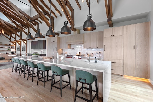 6869 S Gozzer Rd Unit C201, Harrison, ID 83833 - kitchen featuring high vaulted ceiling, modern cabinets, beamed ceiling, backsplash, and stove