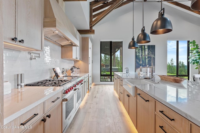 6869 S Gozzer Rd Unit C201, Harrison, ID 83833 - kitchen with custom range hood, range with two ovens, a sink, light brown cabinets, and beamed ceiling