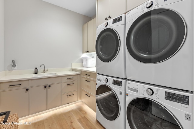6869 S Gozzer Rd Unit C201, Harrison, ID 83833 - laundry room with stacked washing machine and dryer, cabinet space, light wood-type flooring, and washer and dryer