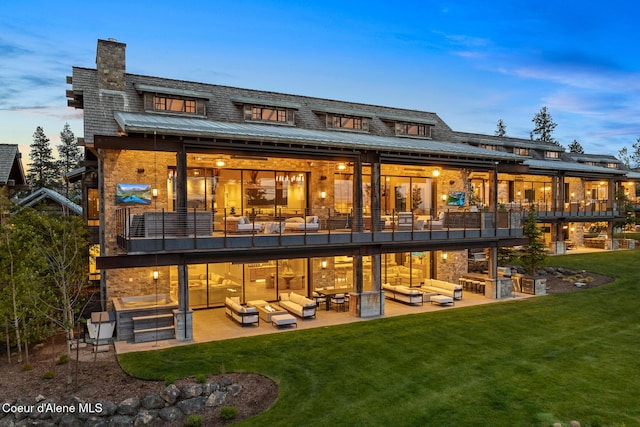 6869 S Gozzer Rd Unit C201, Harrison, ID 83833 - back of property featuring outdoor lounge area, a patio, a balcony, a yard, and a chimney