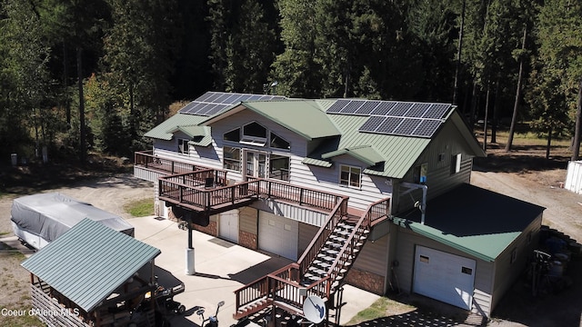 1959 Thimbleberry Ln, Sandpoint, ID 83864 - exterior space with stairs, concrete driveway, a garage, a wooden deck, and solar panels