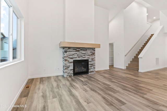 6696 Portrush Dr, Rathdrum, ID 83858 - unfurnished living room with visible vents, a healthy amount of sunlight, wood finished floors, and stairway