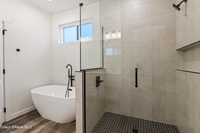 6696 Portrush Dr, Rathdrum, ID 83858 - full bathroom with baseboards, a freestanding bath, a shower stall, and wood finished floors
