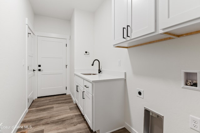 6696 Portrush Dr, Rathdrum, ID 83858 - laundry room featuring cabinet space, a sink, baseboards, light wood-type flooring, and hookup for an electric dryer