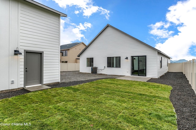 6696 Portrush Dr, Rathdrum, ID 83858 - back of property with a fenced backyard, a patio, a yard, and central AC unit