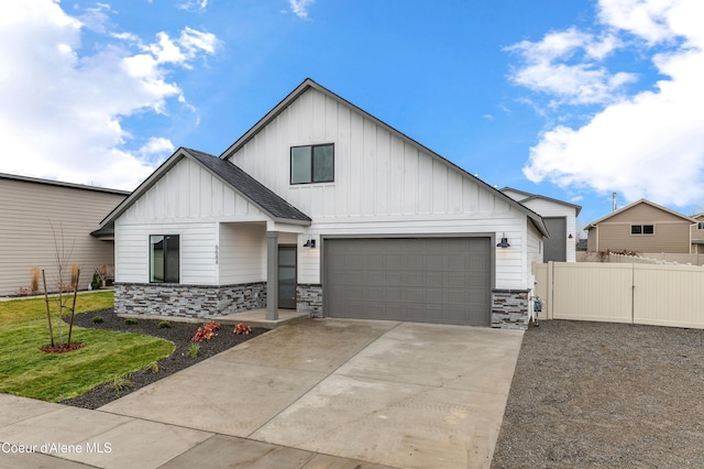 6696 Portrush Dr, Rathdrum, ID 83858 - view of front of house with board and batten siding, fence, concrete driveway, and stone siding