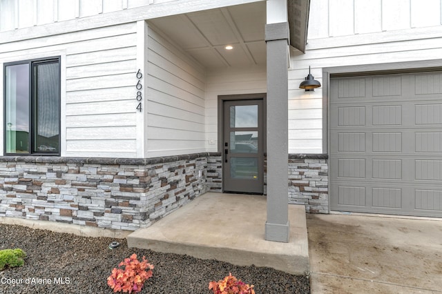 6696 Portrush Dr, Rathdrum, ID 83858 - property entrance with a garage, board and batten siding, and stone siding