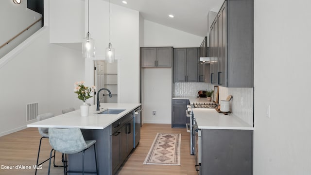 6696 Portrush Dr, Rathdrum, ID 83858 - kitchen with dishwasher, a sink, light wood-type flooring, decorative backsplash, and light countertops